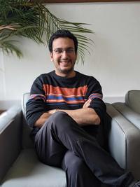 A man sitting in a grey chair smiling